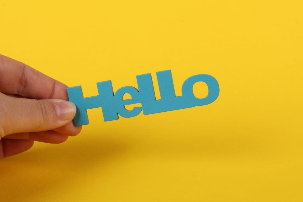 close up photo of a person holding a hello text on yellow background